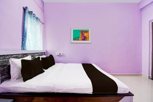 Āsansol的住宿－SPOT ON Hotel Sunshine Lodging，一间卧室设有紫色的墙壁和一张大床
