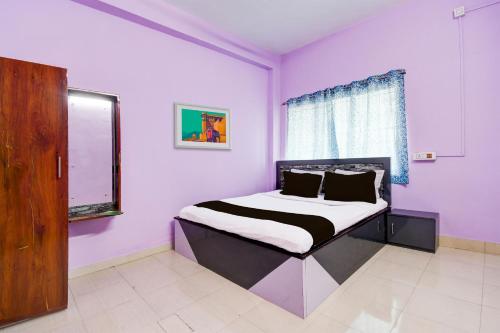 Āsansol的住宿－SPOT ON Hotel Sunshine Lodging，一间卧室配有一张紫色墙壁和窗户的床