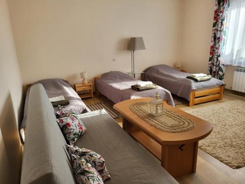 ein Wohnzimmer mit 2 Betten und einem Couchtisch in der Unterkunft Magnolia in Sobolew