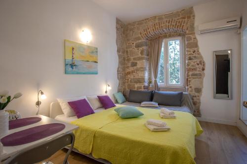 a bedroom with a bed with a yellow blanket at Old Town Historic Core in Split