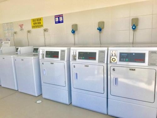 a row of white washers and dryers in a room at Departamento Peñuelas Sol Marina III La Serena - Coquimbo in Coquimbo