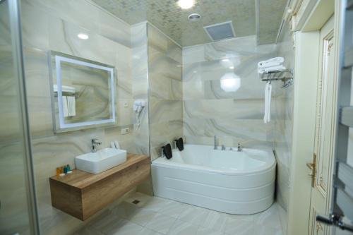 a bathroom with a sink and a tub and a toilet at The Krone in Baku