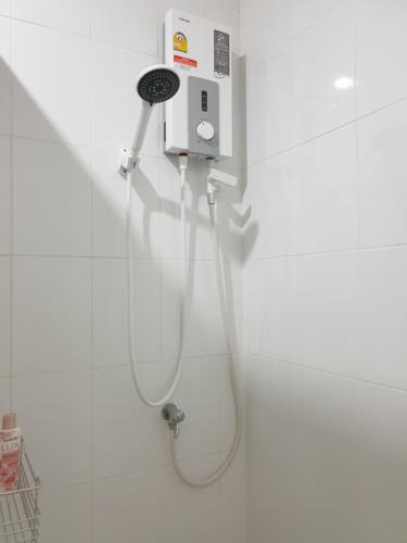 a shower in a white tiled bathroom with a hose at House in community mall, spacious 6 people, 3BR in Chiang Mai