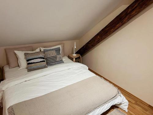 Un dormitorio con una cama blanca con almohadas. en Stilvolle Stadtwohnung - Self Check-in mit guten Parkmöglichkeiten, en Graz