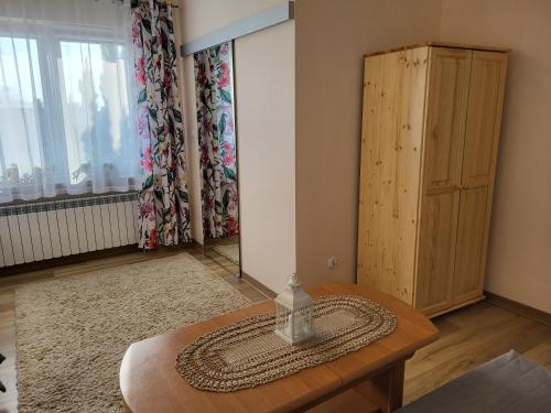 ein Wohnzimmer mit einem Tisch und einem Fenster in der Unterkunft Magnolia in Sobolew