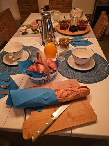 a table with plates of food and a knife at Domaine mon doux rêve in Terrasson-Lavilledieu