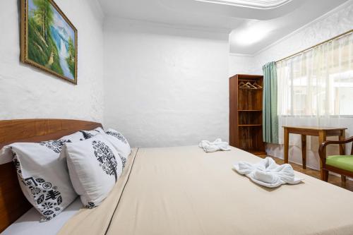 a bedroom with a bed with towels on it at La Peregrina Galapagos B&B in Puerto Ayora