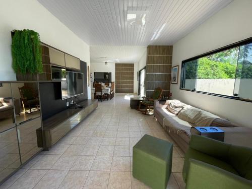 ein Wohnzimmer mit Couch und Flachbildfernseher in der Unterkunft Casa à Beira-mar de Peroba in Peroba