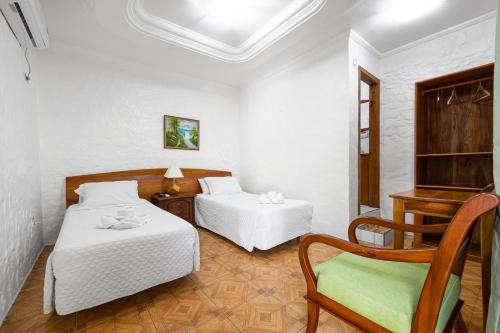 a room with two beds and a chair in it at La Peregrina Galapagos B&B in Puerto Ayora