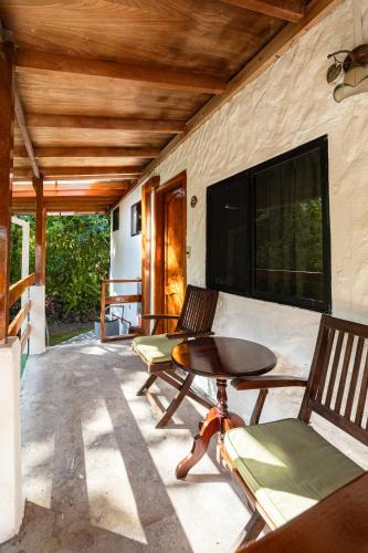 a patio with two chairs and a table on a porch at La Peregrina Galapagos B&B in Puerto Ayora