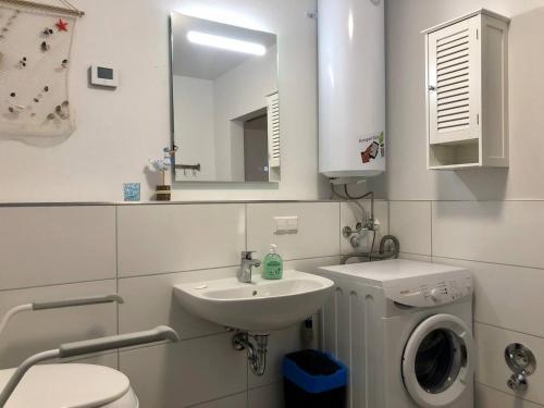 a bathroom with a sink and a toilet and a mirror at Janines Loft - Am Marktplatz Steinhude - 190 Meter zum Meer in Steinhude