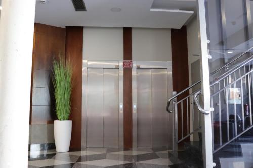 a metal elevator in a building with a plant at HOTEL ARZÚA in Arzúa