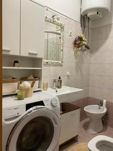 a bathroom with a washing machine and a sink at Adela in Zadar