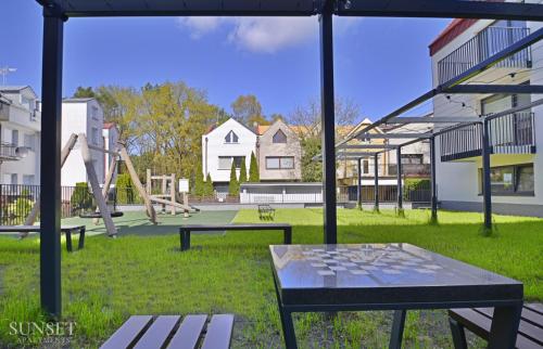 einen Park mit einem Tisch und einem Spielplatz in der Unterkunft Sunset Apartments - Roosevelta - Premium - Garaż in Świnoujście