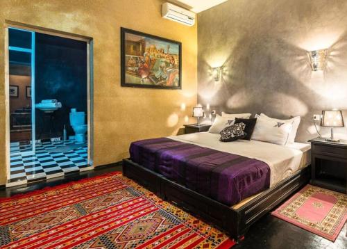 a bedroom with a king sized bed and a bathroom at Riad Ksar Aylan in Ouarzazate