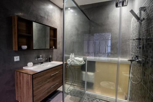 a bathroom with a shower and a sink and a glass shower stall at Riad Ksar Aylan in Ouarzazate