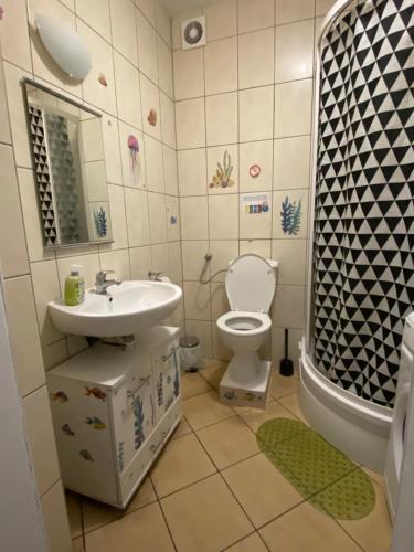 a bathroom with a sink and a toilet and a shower at Jungle Rooms in Gdańsk