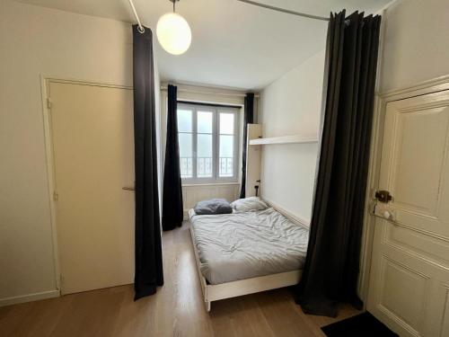 a small bedroom with a bed and a window at Joli appartement plein centre ville in Gérardmer