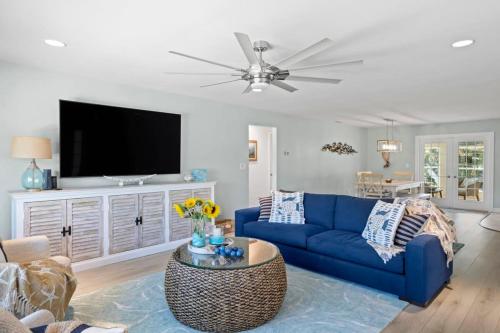 a living room with a blue couch and a tv at On the Rocks- Gorgeous Newly Renovated Pool Home in Sanibel