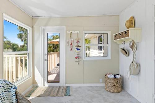 a white room with a door and a balcony at On the Rocks- Gorgeous Newly Renovated Pool Home in Sanibel