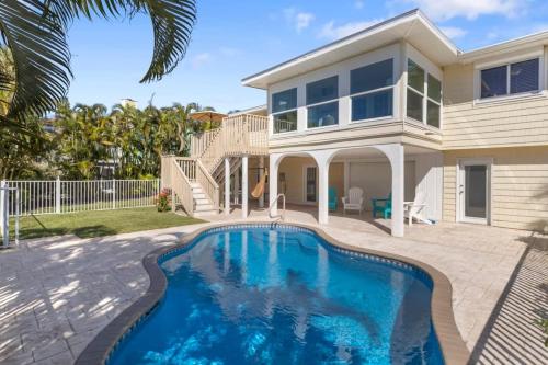 a house with a swimming pool in front of a house at On the Rocks- Gorgeous Newly Renovated Pool Home in Sanibel