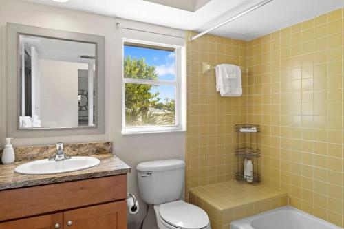 a bathroom with a toilet and a sink and a mirror at On the Rocks- Gorgeous Newly Renovated Pool Home in Sanibel