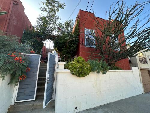 a house with a gate and flowers on a wall at Modern, Bright 2BR Casita in Vibrant Echo Park Silver Lake with Gourmet Kitchen and Unbeatable Proximity to LA Hotspots in Los Angeles