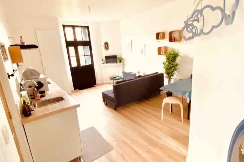 une cuisine et un salon avec un canapé et une table dans l'établissement Jolie maison avec jardin au calme en ville, à Limoges