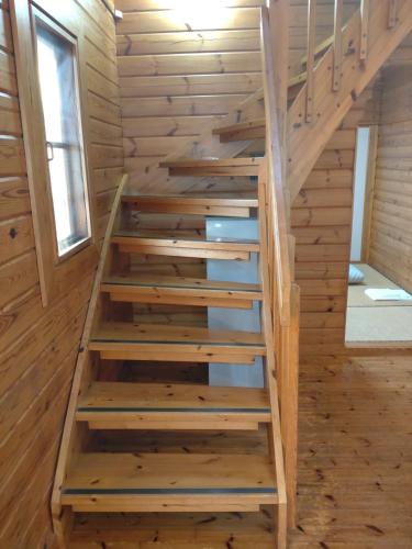 a staircase in a log cabin with wooden walls at Hot Spring Resort Usui Pass Forest Park "Natural H - Vacation STAY 60418v in Karuizawa