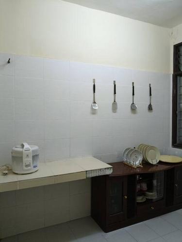 a kitchen with utensils hanging on the wall at Healing Homestay in Kangar