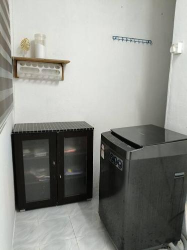 a kitchen with a black counter and a dishwasher at Healing Homestay in Kangar