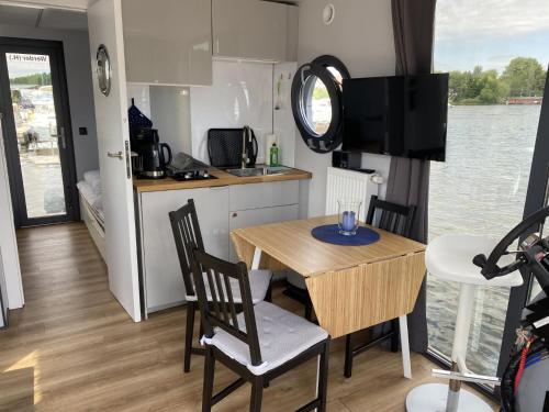 a small kitchen and dining room with a table and chairs at Husbåt in Österhaninge