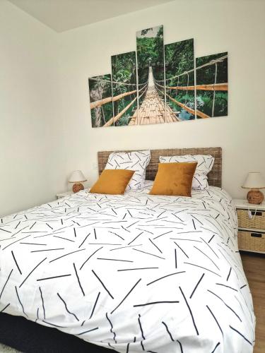 - une chambre avec un lit blanc et deux peintures murales dans l'établissement Le marsault, à Les Sables-dʼOlonne