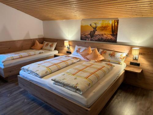 2 Betten in einem Zimmer mit Wandgemälde in der Unterkunft Haus Kammerlander in Stummerberg