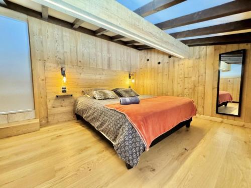 une chambre avec un lit dans un mur en bois dans l'établissement Résidence Les Chardons - Appartement calme avec des vues superbes, à proximité des pistes de ski et des randonnées. MAE-2854, à Notre-Dame-de-Bellecombe