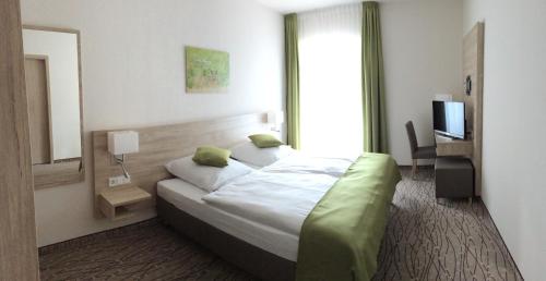 a hotel room with a bed and a television at Landgasthof Hepting in Massenhausen
