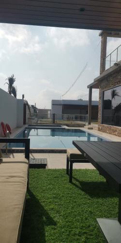 a swimming pool with a bench in the grass at الاستراحة الشموخ in Mu‘tamar