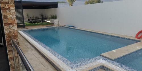 een groot zwembad met blauw water bij الاستراحة الشموخ in Mu‘tamar