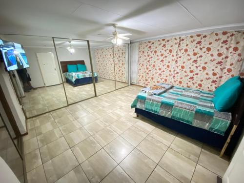 - Vistas aéreas a un dormitorio con cama y espejo en MOMENTS Of JOY GUESTHOUSE AND SPA AT CARNIVAL en Brakpan
