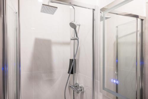 een douche met een douchekop in de badkamer bij C'est La Vie Boutik Swieqi in Is-Swieqi
