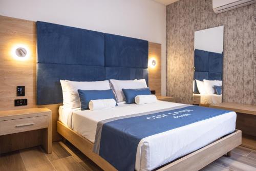 C'est La Vie Boutik Swieqi في Is-Swieqi: غرفة نوم مع سرير كبير مع اللوح الأمامي الأزرق