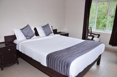 Tempat tidur dalam kamar di Munnar Mount Shelt Hotel