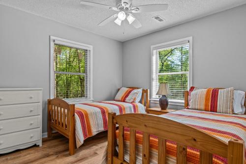 1 dormitorio con 2 camas y ventilador de techo en Beaverdam Bliss Cabin on 14 acres, en Madison