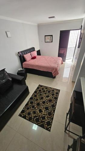 a living room with a bed and a rug at Apartamento Flat Palladium completo e mobiliado in São Vicente