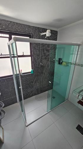 a shower with a glass door in a bathroom at Apartamento Flat Palladium completo e mobiliado in São Vicente
