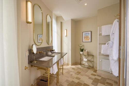 a bathroom with two sinks and two mirrors at Maison 1896 in Beaune