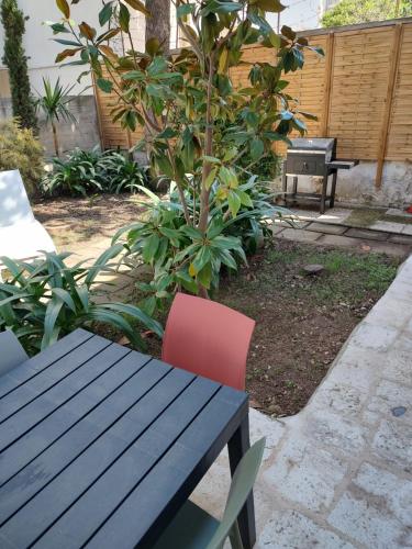 a wooden table and a red chair next to a tree at BariMetro Garden in Capurso