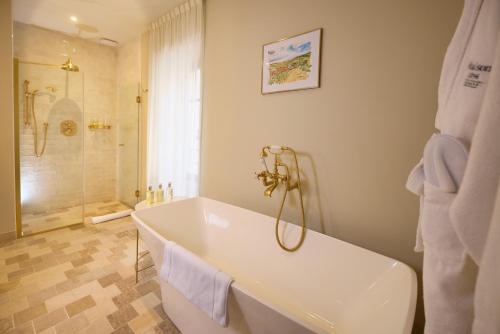a white bathroom with a tub and a shower at Maison 1896 in Beaune