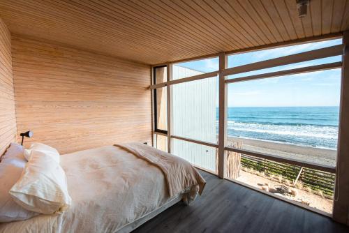 1 dormitorio con 1 cama y ventana grande con vistas al océano en Casa Nek #2 Primera línea Matanzas, en Matanzas