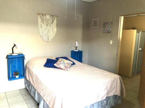 een slaapkamer met een bed en twee blauwe nachtkastjes bij Hostal Notas y Puntadas a 1,2 Kms del Centro Historico de Santa Ana in Santa Ana